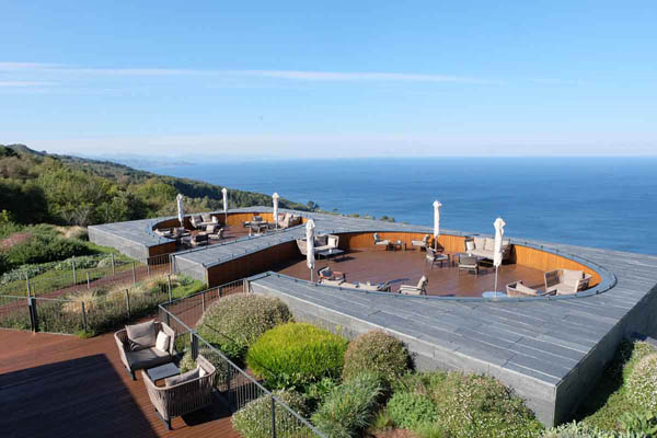 Panorámica de la terraza del hotel Akelarre con diferentes zonas para sentarse y de fondo el mar