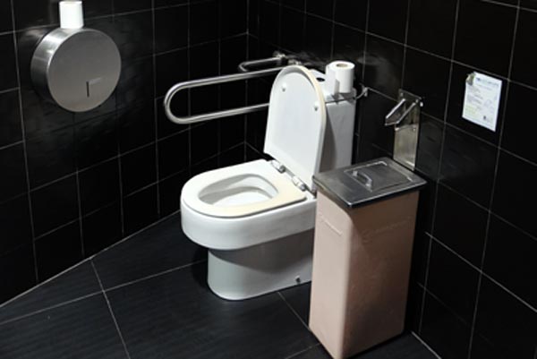 Lavatory with a movable support rail on one side in one of the toilets. 