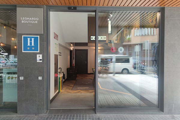 Puerta corredera de acceso al hotel con logo y rótulo del hotel.