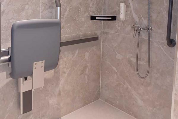 Douche de la salle de bains de la chambre adaptée siège rabattable et barre de support fixe.