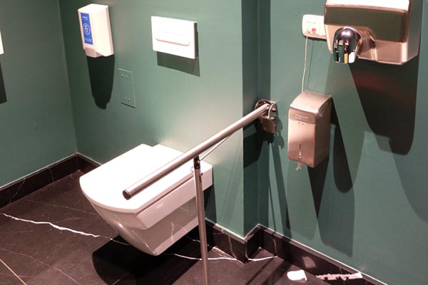 Adapted toilet shared between the restaurant and reception with a rail on the left-hand side. 