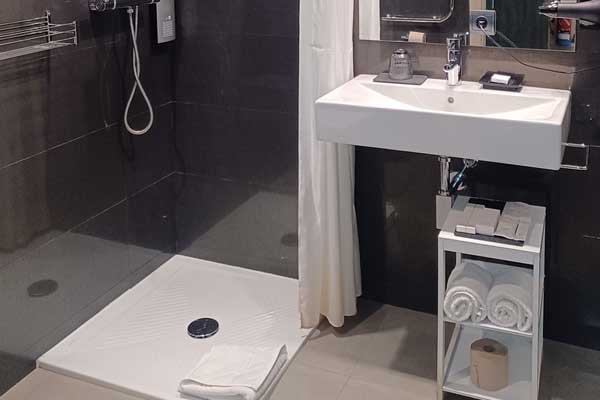 Douche et lavabo de la salle de bains de l’appartement adapté.