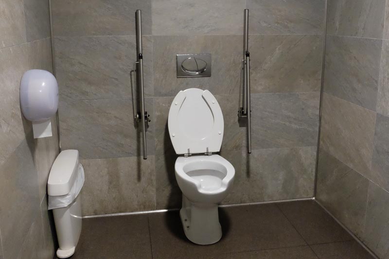 Support rails on both sides of the lavatory in the adapted toilet in the cafe.