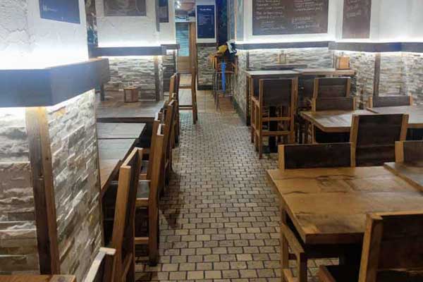 Salle à manger avec tables et chaises de chaque côté du couloir.
