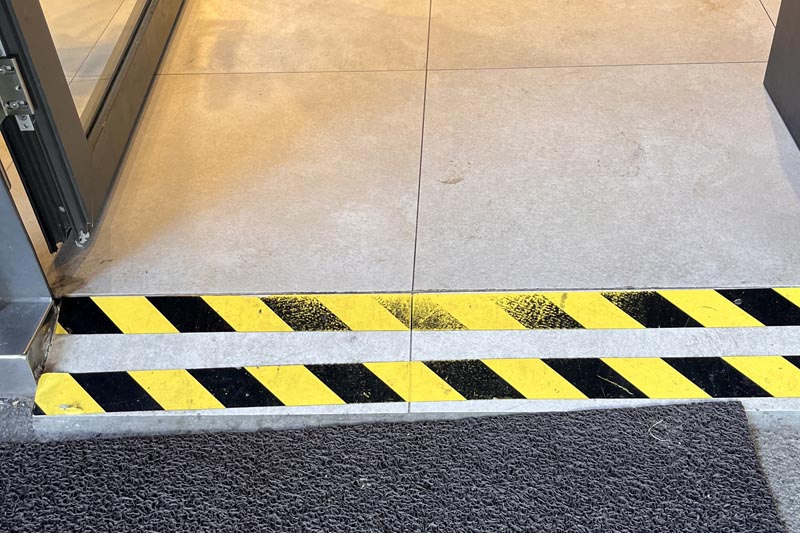 Access ramp from terrace marked with black and yellow tape. 