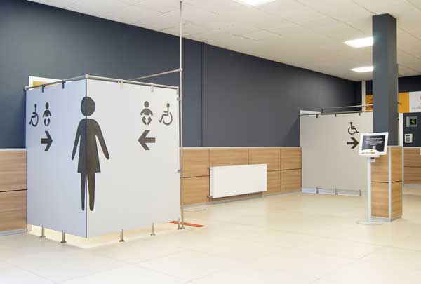 Cloison avec les pictogrammes indiquant l’emplacement des toilettes