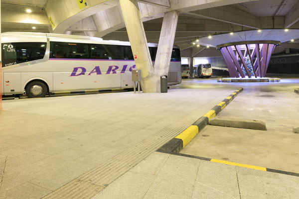 Dársena accesible de la estación de autobuses de San Sebastián. Señalización amarilla y negra en los extremos y pavimento podotáctil.