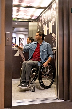 Hombre en silla de ruedas en el ascensor de un hotel