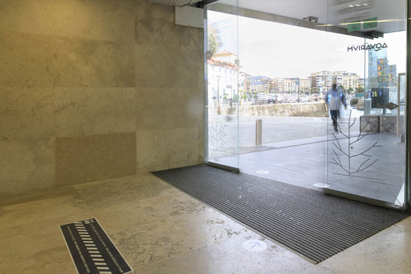 Entrada del Aquarium desde el interior. Puertas automáticas de cristal y alfombra incorporada en el pavimento.