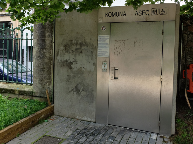 Façade des toilettes adaptées du parc Cristina-Enea. Cabine métallique avec signalétique de pictogrammes en partie haute.