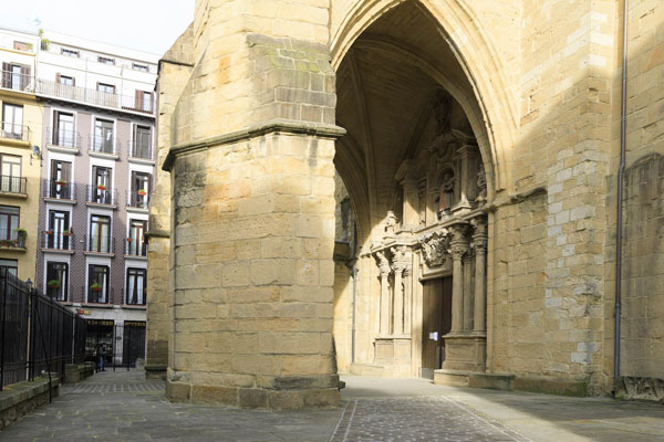 Acceso lateral al recinto de la Iglesia de San Vicente, pavimento adoquinado.