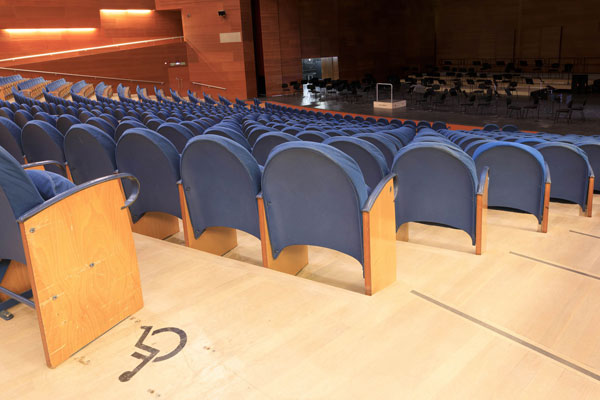 Plaza PMR del auditorio del Kursaal, junto al resto de butacas y señalizada mediante pictograma en el suelo en color negro.