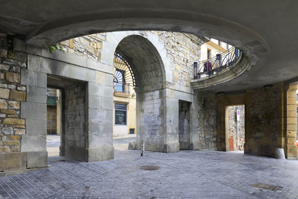 Access to the old town of San Sebastian through a stone arch with three openings. 