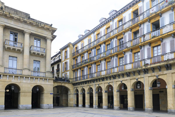 Façade des maisons qui composent la Plaza de la Constitución. Couleurs : bleu, jaune et blanc. 