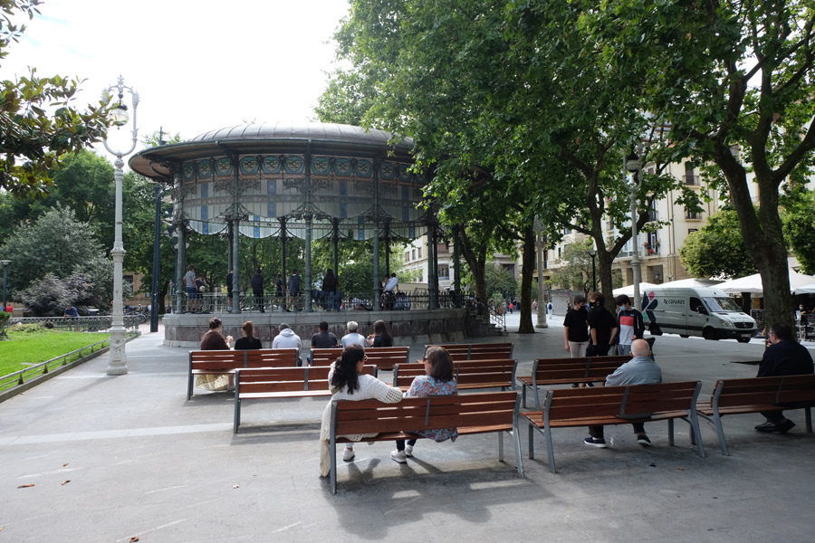 Kiosque du boulevard avec des gens assis sur des bancs