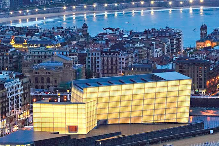 Aerial view of the Kursaal Center at dusk with La Concha beach in the background
